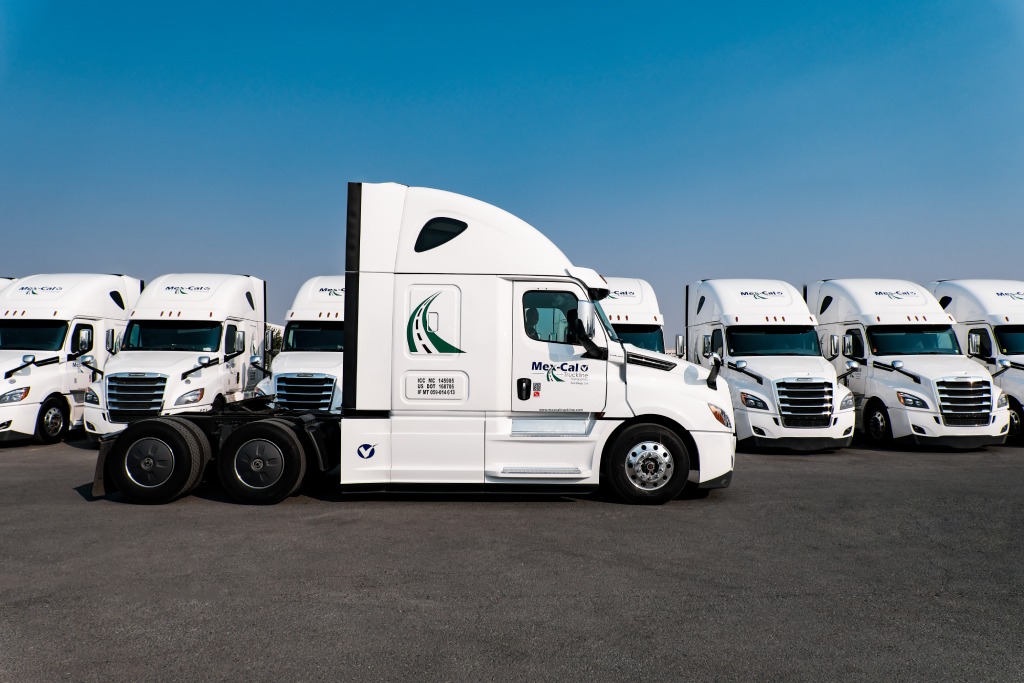 A group of semi trucks from the Mexcal Truckline fleet parked in a parking lot