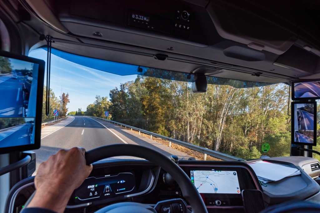 View from the driver's position of a truck on the road of the interior of the cabin with the screens as rearview mirrors.