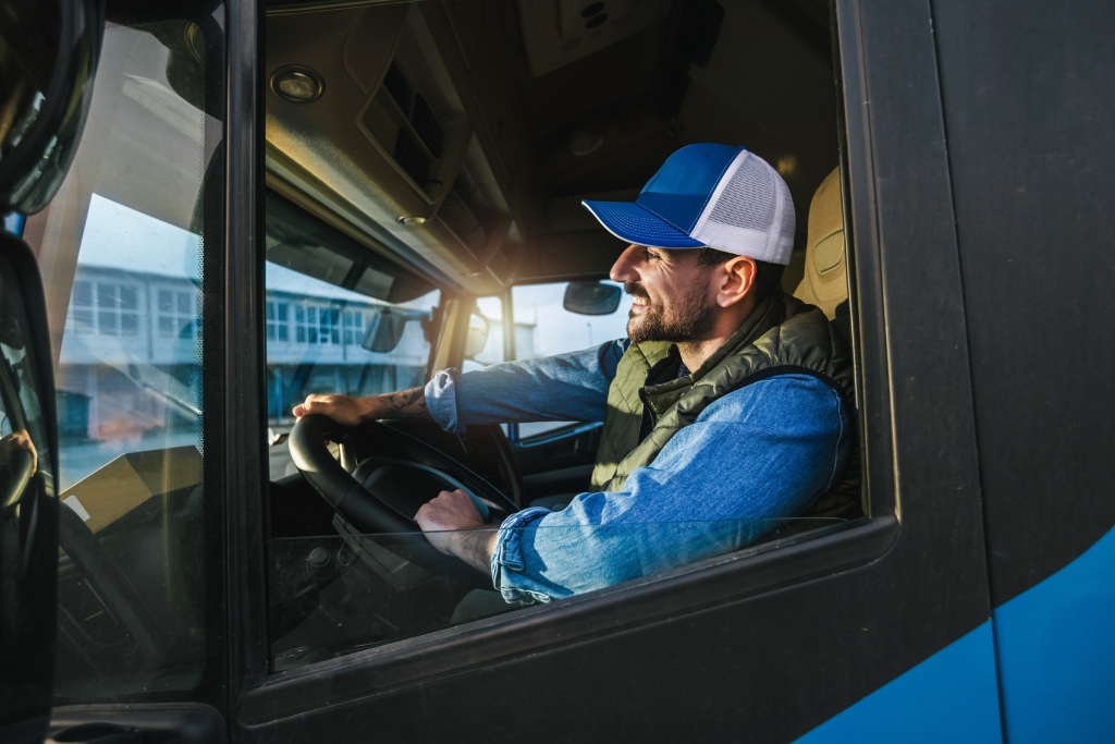 Young handsome truck driver driving a truck.